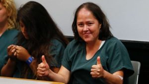 Woman accused of killing her children, husband poses for pictures at court appearance